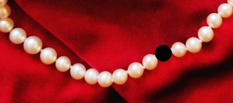 dettaglio di collana a cui manca una perla